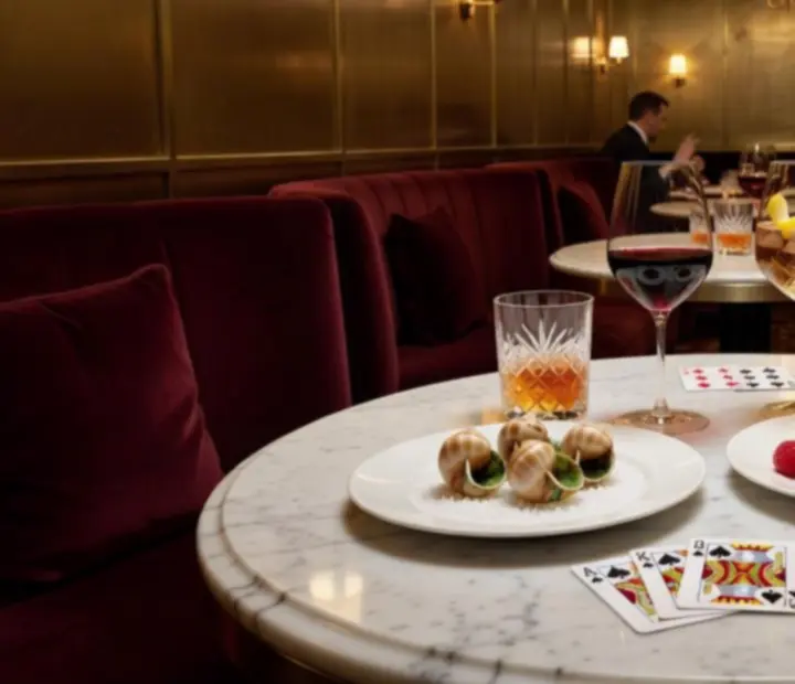 Assiettes à partager et cocktails élégants servis autour d'une table de jeu