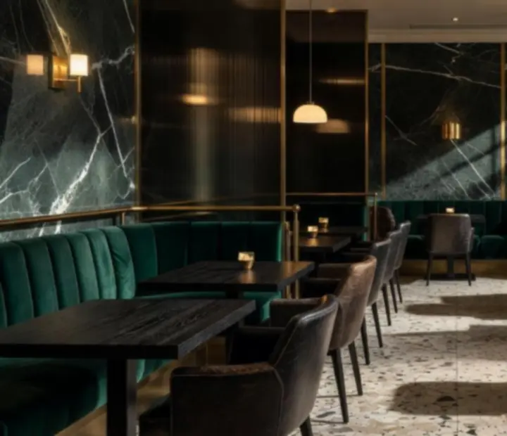 Intérieur de restaurant Art Déco avec marbre vert, verre fumé et laiton brossé.